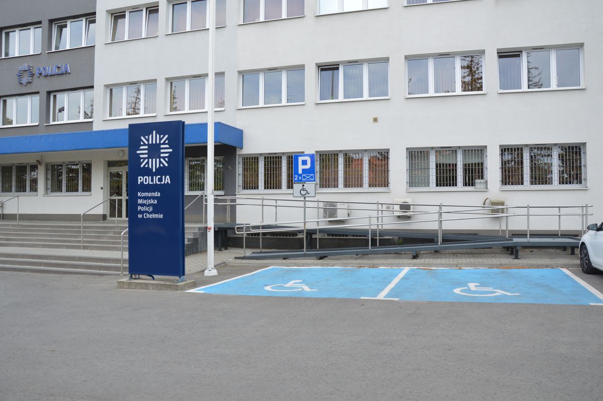 Dwa miejsca parkingowe dla osób z niepełnosprawnościami obok schodów i podjazdu prowadzących do wejścia do budynku