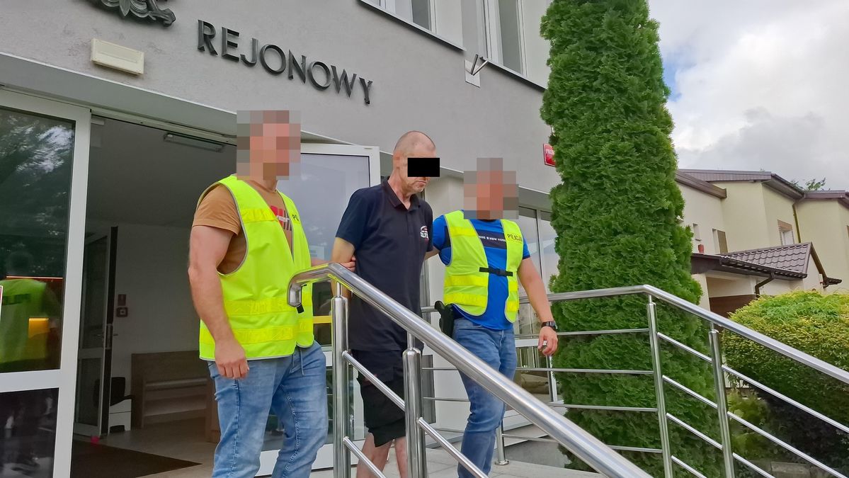 Policjanci wyprowadzają zatrzymanego z sądu.