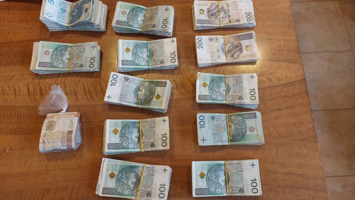 Zabezpieczone przez policjantów pieniądze w banknotach spietych w pliki