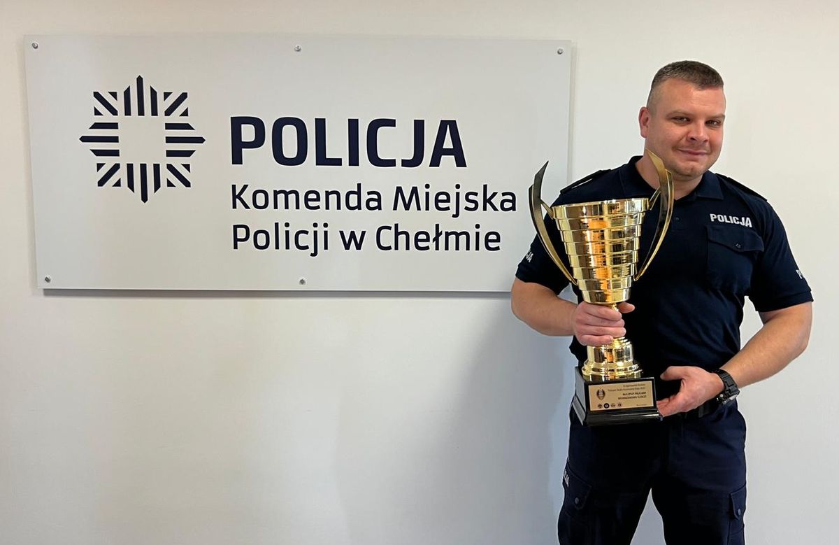 Policjant z pucharem w rękach.
