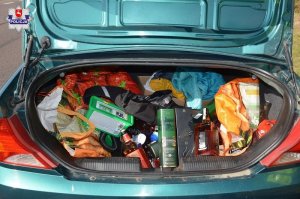 Otwarty bagażnik samochodu ze skradzionymi produktami w środku
