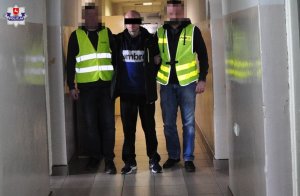 Mężczyzna trzymany przez dwóch policjantów