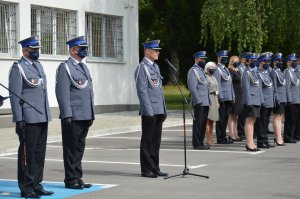 Na zdjęciu młodszy inspektor Mariusz Kołtun wraz z zastępcami komendanta i kadrą kierowniczą. W tle budynek komendy.