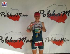 Stojąca na podium w stroju sportowym i z medalami aspirant Iwona Panas.