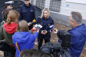 Policjanci oraz dziennikarze przed budynkiem komendy