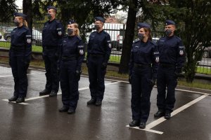Sześcioro nowych policjantów na placu przed budynkiem komendy.