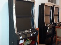Trzy automaty do gier hazardowych stojące w pomieszczeniu