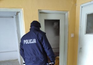 Policjant stojący przy drzwiach w budynku