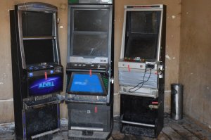 Trzy automaty do gier hazardowych stojące w pomieszczeniu
