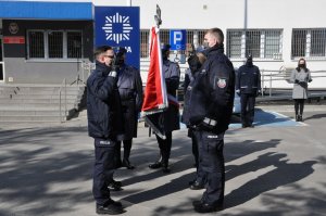 Ślubowanie policjantów na sztandar, w tle budynek komendy.