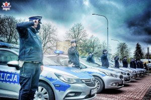 Policjanci stojący przy radiowozach