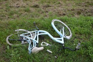 Leżący na trawie uszkodzony rower