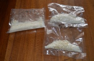 Trzy torebki foliowe z mefedronem leżące na blacie