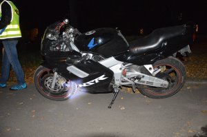 Motocykl stojący na poboczu i policjant