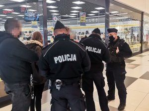 Policjanci legitymujący osoby w centrum handlowym.