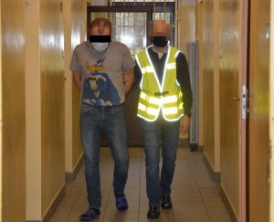 Policjant z zatrzymanym mężczyzną.