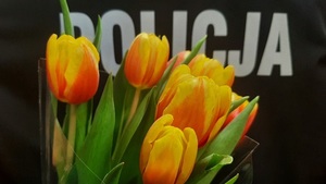 Kwiaty na tle munduru z napisem Policja