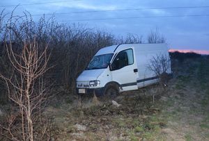 Bus stojący na polu przy zaroślach