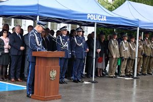 Przemówienie Komendanta Miejskiego Policji w Chełmie młodszego inspektora Mariusza Kołtuna. W tle zaproszeni goście stojący pod namiotem.