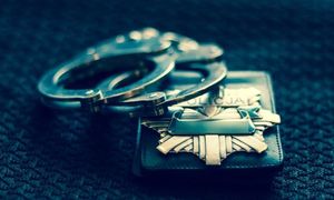 Kajdanki i policyjna odznaka.