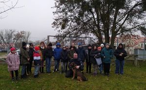 Uczniowie z policjantem i psem służbowym.