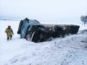 Przewrócona cysterna, obok niej strażak.