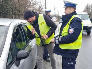 Policjant i egzaminator nauki jazdy podczas kontroli drogowej.