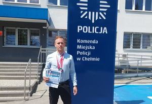zdjęcie policjanta z medalami na szyi trzymającego dyplomy