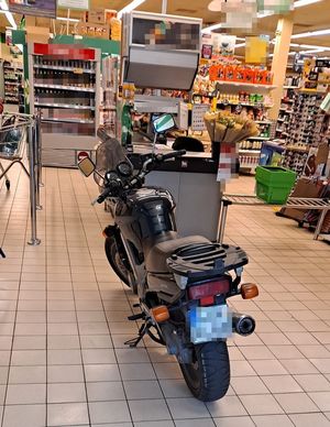 Motocykl w sklepie, w tle regały sklepowe.