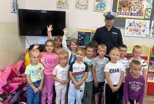 Policjant z dziećmi w szkolnej sali.