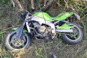Uszkodzony motocykl leżący na ziemi.