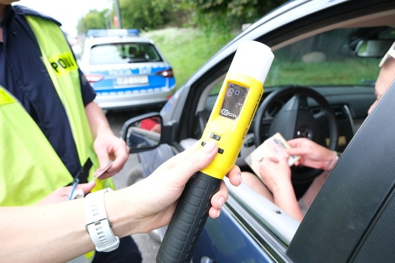 Policjanci podczas kontroli drogowej sprawdzają stan trzeźwości kierowcy.