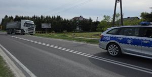 Samochód ciężarowy i radiowóz na jezdni.
