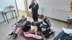 Udzielanie pierwszej pomocy przedmedycznej w symulacji upadku na deskorolce.