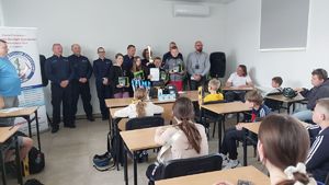 Zwycięzcy turnieju w młodszej grupie wiekowej pozują do zdjęcia z organizatorami.