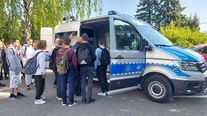 Młodzież ogląda prezentowany przez policjantów radiowóz.
