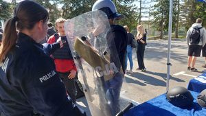 Uczeń mierzy policyjny sprzęt do zabezpieczeń.