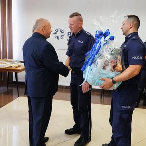 Odchodzący na zaopatrzenie emerytalne policjant przyjmuje życzenia od Pierwszego Zastępcy Komendanta Miejskiego Policji w Chełmie.