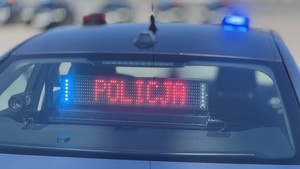 Radiowóz nieoznakowany z podświetlonym na czerwono napisem &quot;Policja&quot; na tylnej szybie.