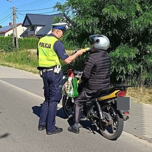 Policjant sprawdza trzeźwość motocyklisty.