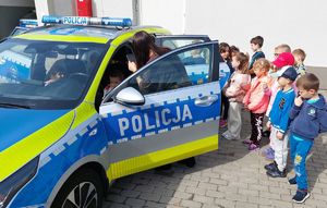 Dzieci oglądają wnętrze radiowozu.