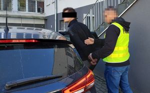 Policjant z zatrzymanym przy nieoznakowanym radiowozie.