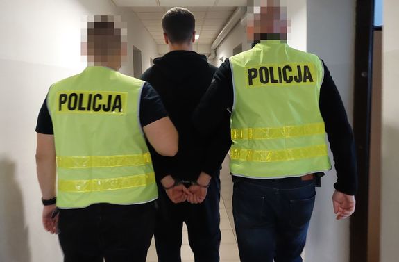 Policjanci prowadza zatrzymanego mężczyznę