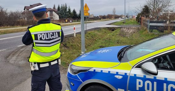 Policjant z miernikiem prędkości przy drodze