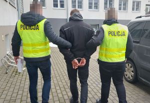 Policjanci prowadza zatrzymanego mężczyznę