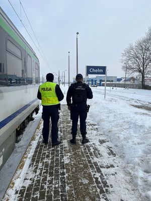 Zdjęcie przedstawiające funkcjonariusza Policji oraz Straży Ochrony Kolei, którzy wspólnie patrolują tereny kolejowe
