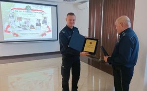 I Zastępca Komendanta Miejskiego Policji w Chełmie wręcza aspirantowi sztabowemu Kazimierzowi Szewczukowi pamiątkową tabliczkę.