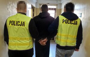 Policjanci prowadzą zatrzymanego