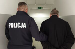 Zatrzymany prowadzony przez umundurowanego policjanta