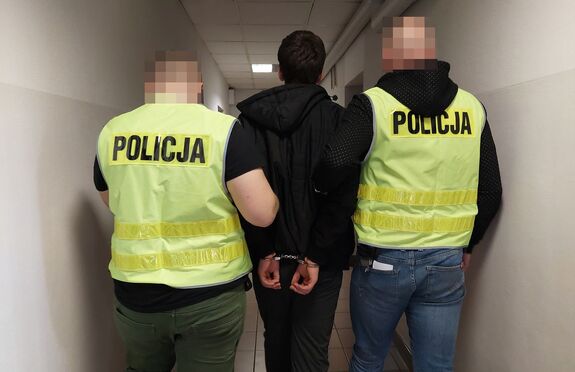 Policjanci prowadzą zatrzymanego mężczyznę